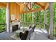 Inviting screened porch with wooden beams, stone fireplace, and lush greenery at 2848 Tanner Lake Nw Trl, Marietta, GA 30064