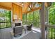 Cozy screened porch boasts stone fireplace, wooden ceiling, and serene forest view at 2848 Tanner Lake Nw Trl, Marietta, GA 30064