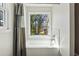 Clean bathroom featuring a tub, a window and tiled walls at 6165 Short St, Canton, GA 30114