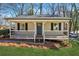 Charming home featuring a covered front porch, neutral siding, black shutters, and a well-maintained lawn at 6165 Short St, Canton, GA 30114