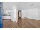 Open-concept space features white walls, wood-look flooring, and an adjacent kitchen with white cabinets at 6165 Short St, Canton, GA 30114