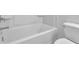 Clean white bathroom with a tub and shower combination and white toilet at 76 Auburn Run Ln, Auburn, GA 30011