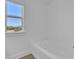 Bright bathroom featuring a large bathtub and a window offering a view of the beautiful, sunny landscape at 76 Auburn Run Ln, Auburn, GA 30011