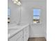 Bright bathroom featuring a double sink vanity, quartz countertop, and a window providing a peaceful view at 76 Auburn Run Ln, Auburn, GA 30011