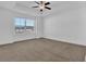 Bright bedroom featuring plush carpeting, ceiling fan, and a large window at 76 Auburn Run Ln, Auburn, GA 30011