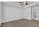 Bright, neutral bedroom featuring plush carpets and an ensuite bathroom with a glass-enclosed shower at 76 Auburn Run Ln, Auburn, GA 30011