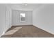 A bright bedroom with plush carpeting and a large window for natural light at 76 Auburn Run Ln, Auburn, GA 30011