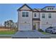 Well-manicured lawn leads to a modern townhome with attached garage and driveway at 76 Auburn Run Ln, Auburn, GA 30011