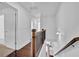 Second-floor hallway showcasing the open staircase and a glimpse into the kitchen below at 76 Auburn Run Ln, Auburn, GA 30011