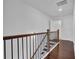 Hallway with hardwood floors and wooden railing, leading to bedrooms at 76 Auburn Run Ln, Auburn, GA 30011