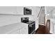 Kitchen with white cabinets, stainless steel appliances, and stairs nearby at 76 Auburn Run Ln, Auburn, GA 30011