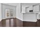 Open concept kitchen and dining space, featuring hardwood floors and bright white cabinets at 76 Auburn Run Ln, Auburn, GA 30011