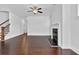 Cozy living room with dark hardwood floors and fireplace, next to the stairs at 76 Auburn Run Ln, Auburn, GA 30011
