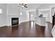 Bright living room featuring hardwood floors, fireplace, ceiling fan, and open concept layout at 76 Auburn Run Ln, Auburn, GA 30011
