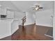 Open concept living room with hardwood floors, kitchen bar, and stairway view at 76 Auburn Run Ln, Auburn, GA 30011