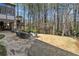 Inviting backyard featuring a stone patio, well-maintained lawn, and a serene wooded area at 302 W Country Dr, Johns Creek, GA 30097
