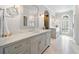 This elegant bathroom features double sinks with marble countertops, a large mirror, and tile flooring at 302 W Country Dr, Johns Creek, GA 30097