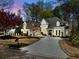 Stunning two-story home with a circular driveway and lush landscaping at 302 W Country Dr, Johns Creek, GA 30097