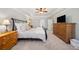 This cozy main bedroom features neutral paint, a large dresser, and a TV at 302 W Country Dr, Johns Creek, GA 30097