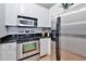 Modern kitchen with stainless steel appliances, white cabinets, and dark granite countertops at 10 Perimeter Summit Ne Blvd # 1208, Brookhaven, GA 30319