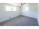 Neutral bedroom with ceiling fan, two windows and carpet flooring at 6175 Marilla St, Douglasville, GA 30135
