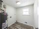 Bright laundry room with wood-look floors and a new hot water heater at 6175 Marilla St, Douglasville, GA 30135