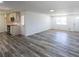 Open living room with an adjoining kitchen, featuring gray flooring, white walls, and natural light at 6175 Marilla St, Douglasville, GA 30135