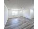 Bright, spacious living room with gray wood-look floors, white walls, and ample natural light at 6175 Marilla St, Douglasville, GA 30135