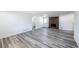 Bright living room with neutral walls, brick fireplace, and modern gray wood-look flooring at 6175 Marilla St, Douglasville, GA 30135