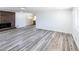 Open living space with white walls, a brick fireplace, and durable gray wood-look flooring at 6175 Marilla St, Douglasville, GA 30135