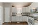 Modern kitchen with white cabinets, stainless steel appliances, and black countertops at 1270 Della Way, Lawrenceville, GA 30043