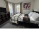 Comfortable bedroom with a queen bed, modern decor, and two windows for ample natural light at 3533 Johns Rd, Tucker, GA 30084