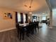 Open-concept dining area featuring modern lighting, gray plank floors and a view into the adjacent living room at 3533 Johns Rd, Tucker, GA 30084