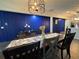 Charming dining room featuring a vibrant blue accent wall, modern light fixture, and a rustic wooden table at 3533 Johns Rd, Tucker, GA 30084