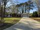 A ranch-style home with a long driveway, covered porch, and a two-car garage surrounded by mature trees at 3533 Johns Rd, Tucker, GA 30084
