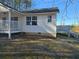 Exterior view of the home showcasing a deck, white siding, and access stairs at 1610 Mulberry Rock Rd, Dallas, GA 30157