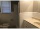 Modest bathroom featuring a toilet, tiled walls, and a single-sink vanity with window view at 1731 Dogwood Trl, Douglasville, GA 30134
