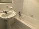 This well-lit bathroom has a pedestal sink and a built-in tub and shower combination at 1731 Dogwood Trl, Douglasville, GA 30134