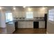 Well-lit kitchen featuring white cabinets, a window, and black appliances at 1731 Dogwood Trl, Douglasville, GA 30134
