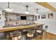Finished basement bar features brick backsplash, wood accents and fixtures, and seating for entertaining at 7740 Nesbit Ferry Rd, Atlanta, GA 30350