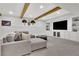 Finished basement with a comfortable sectional, built-in shelving, and wood beam accents at 7740 Nesbit Ferry Rd, Atlanta, GA 30350