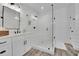 Elegant bathroom features a glass-enclosed shower, shiplap walls, and marble countertops at 7740 Nesbit Ferry Rd, Atlanta, GA 30350