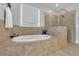 Modern bathroom featuring a soaking tub and glass-enclosed shower with neutral tile surround at 7740 Nesbit Ferry Rd, Atlanta, GA 30350