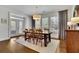 Dining room with a wood table, six chairs, and large windows with natural light at 7740 Nesbit Ferry Rd, Atlanta, GA 30350