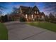Stately home featuring a brick and stone facade, well-manicured landscaping, and a spacious driveway at 7740 Nesbit Ferry Rd, Atlanta, GA 30350
