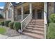 Classic brick stairway leading to a covered porch, complemented by manicured shrubbery and elegant columns at 7740 Nesbit Ferry Rd, Atlanta, GA 30350