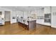 A modern kitchen featuring white cabinets, granite countertops, stainless steel appliances, and a large island with bar seating at 7740 Nesbit Ferry Rd, Atlanta, GA 30350