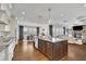 Modern kitchen with island, stainless appliances, granite countertops, and open view to living room at 7740 Nesbit Ferry Rd, Atlanta, GA 30350