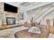 Open-concept living room with stone fireplace, plush seating, and a staircase in the background at 7740 Nesbit Ferry Rd, Atlanta, GA 30350
