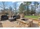 Stone outdoor kitchen featuring built-in grill, cooking space, and seating with a fire pit at 7740 Nesbit Ferry Rd, Atlanta, GA 30350